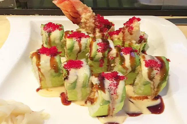 Shrimp tempura avocado rolls with tobiko and sauces at Dragon Sushi, a Japanese Restaurant in New York
