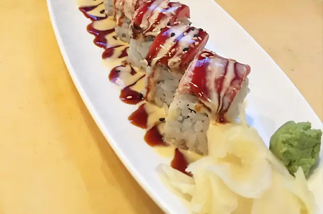 Tuna sushi rolls drizzled with savory sauces at Dragon Sushi, a Japanese Restaurant in New York