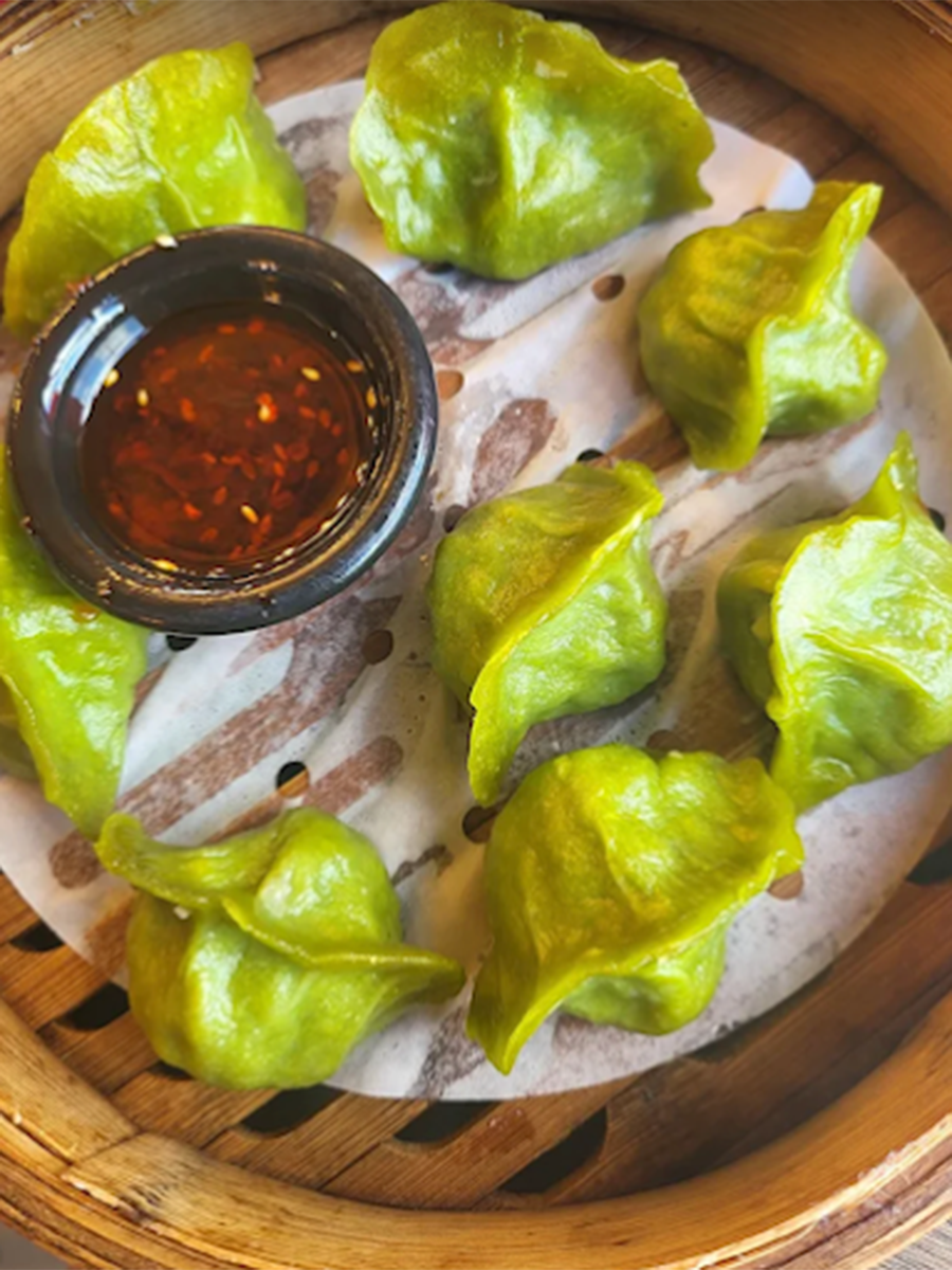 Green dumplings in a steamer, with sauce beside them at Southside Dumpling Haus, a Chinese Restaurant in Corpus Christi