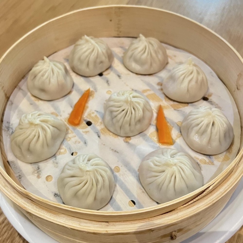 Delicate steamed soup dumplings served in a bamboo steamer at Dumpling King Asian Cuisine in Sacramento