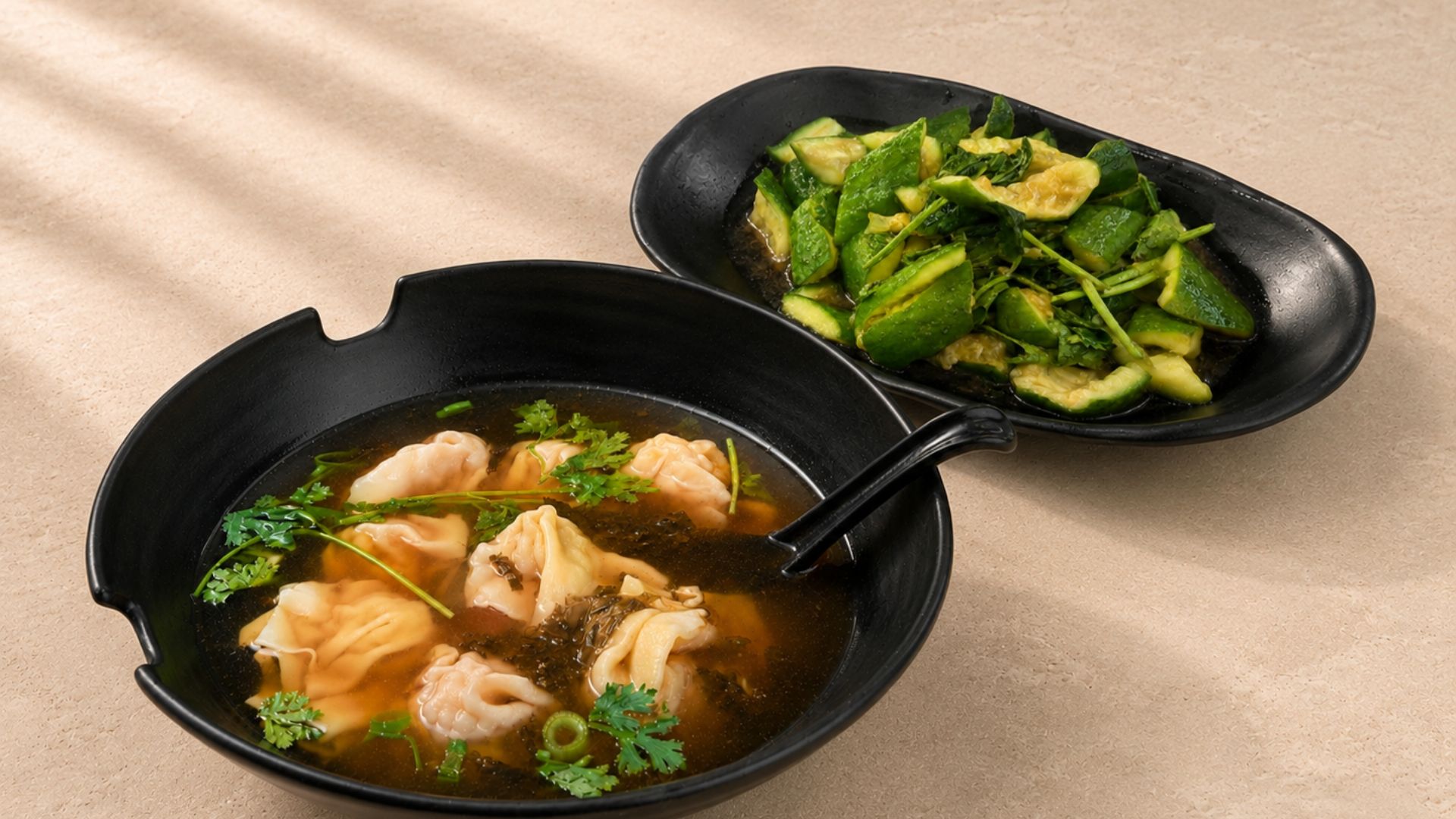 Wonton soup with cilantro and a side of smashed cucumber salad