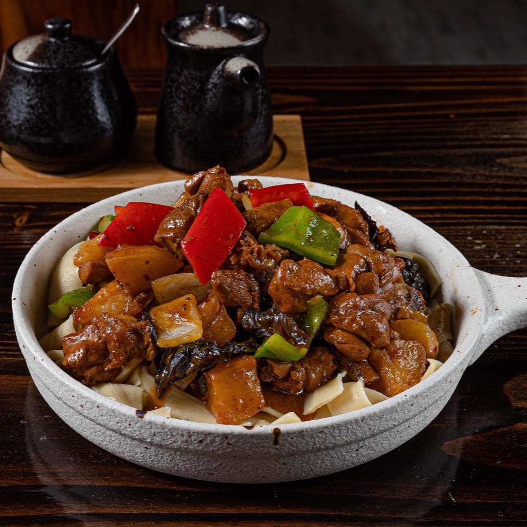 Braised chicken noodles with colorful bell peppers and mushrooms at Dun Huang, a Chinese Restaurant in Brooklyn