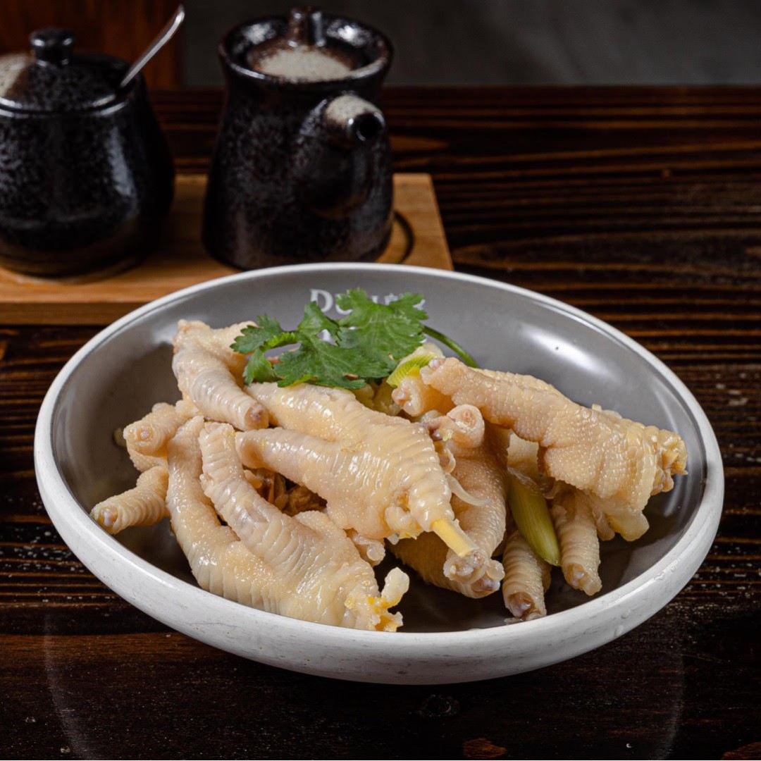 Refreshing marinated chicken feet garnished with cilantro at Dun Huang, a Chinese Restaurant in Brooklyn