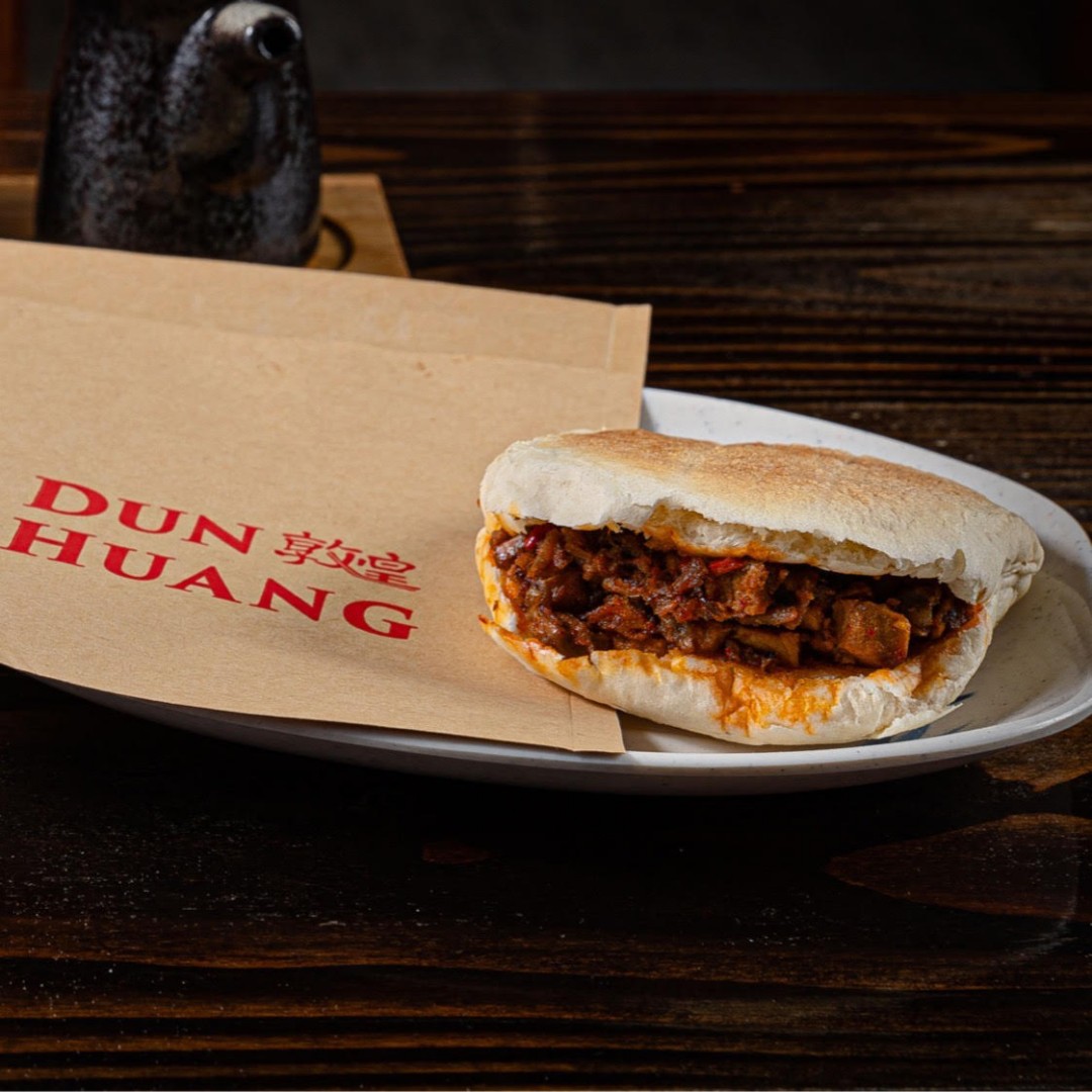 Savory spiced meat burger with tender filling at Dun Huang, a Chinese Restaurant in Brooklyn