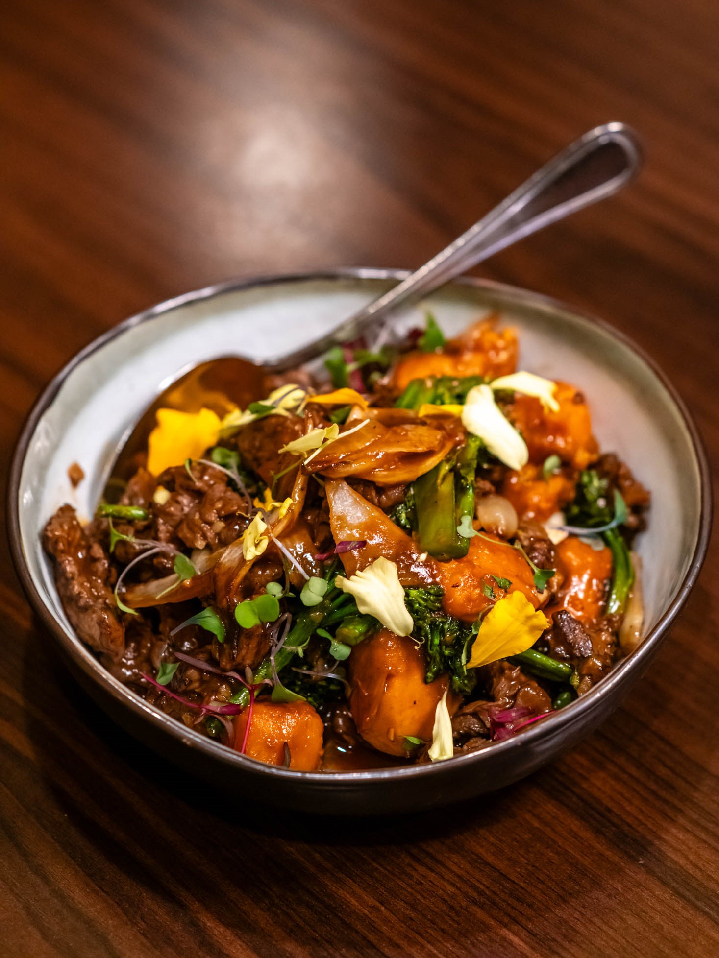 Savory beef stir-fry with broccoli, pumpkin and colorful microgreen garnishes at Canaan Chinese Cuisine, a Chinese Restaurant in CA
