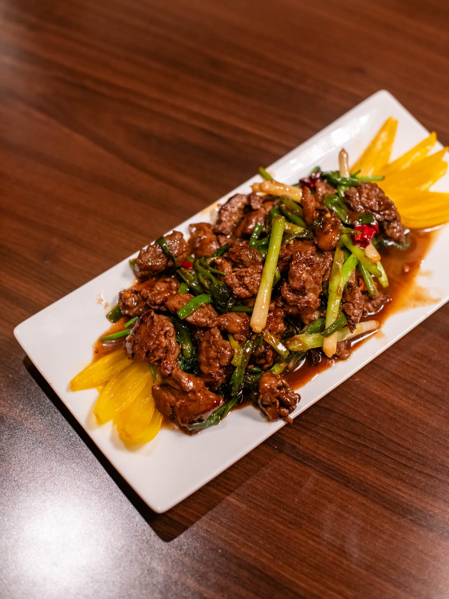 Wok-seared beef slices stir-fried with green onions and red chili peppers at Canaan Chinese Cuisine, a Chinese Restaurant in CA