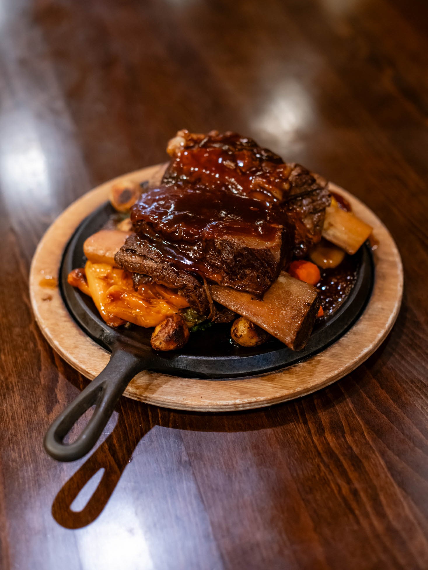 Braised glazed beef short ribs with roasted veggies on sizzling iron skillet at Canaan Chinese Cuisine, a Chinese Restaurant in CA