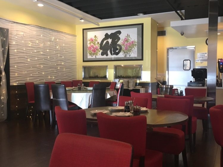 Spacious dining room with red chairs and large Chinese fortune character wall art at Canaan Chinese Cuisine, a Chinese Restaurant in CA