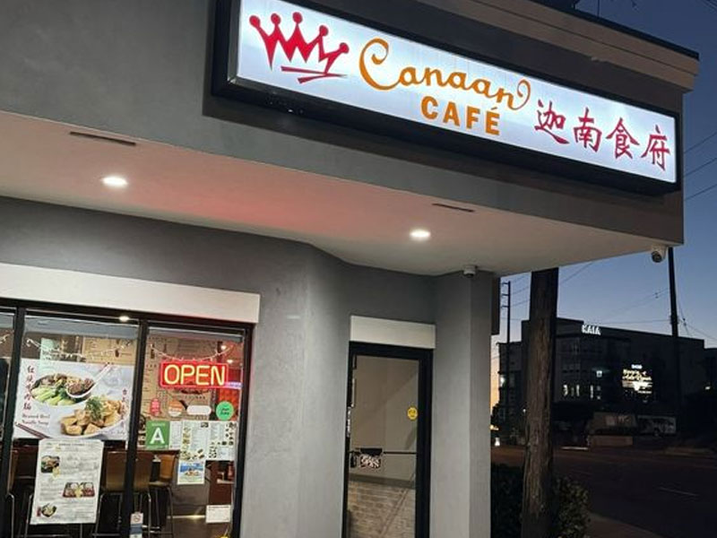 Twilight exterior view of Canaan Cafe restaurant with crown logo and illuminated sign at Canaan Chinese Cuisine, a Chinese Restaurant in West Covina