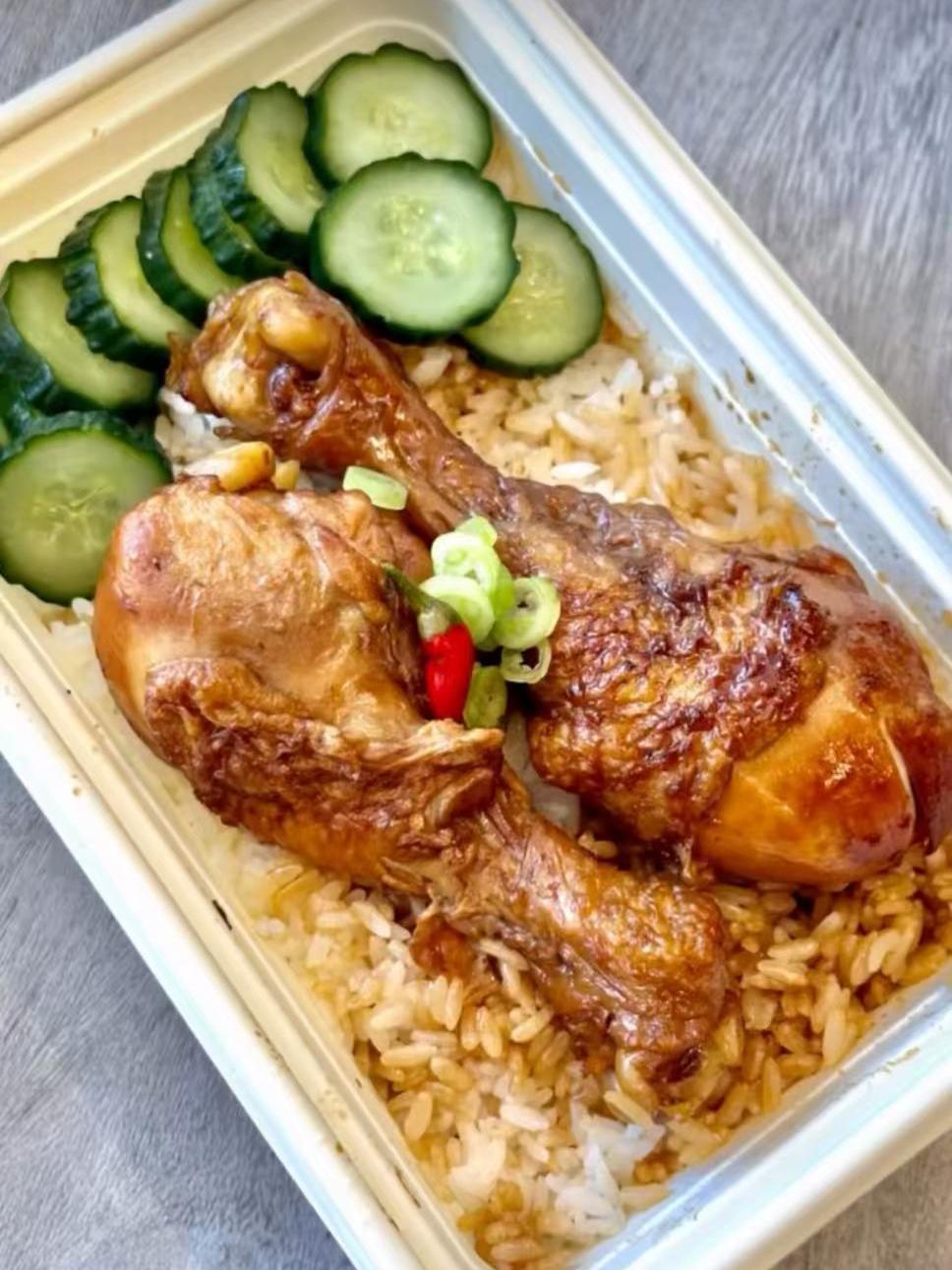 Braised chicken legs served over rice with cucumber slices at EatGrand, a Japanese Restaurant in Los Angeles