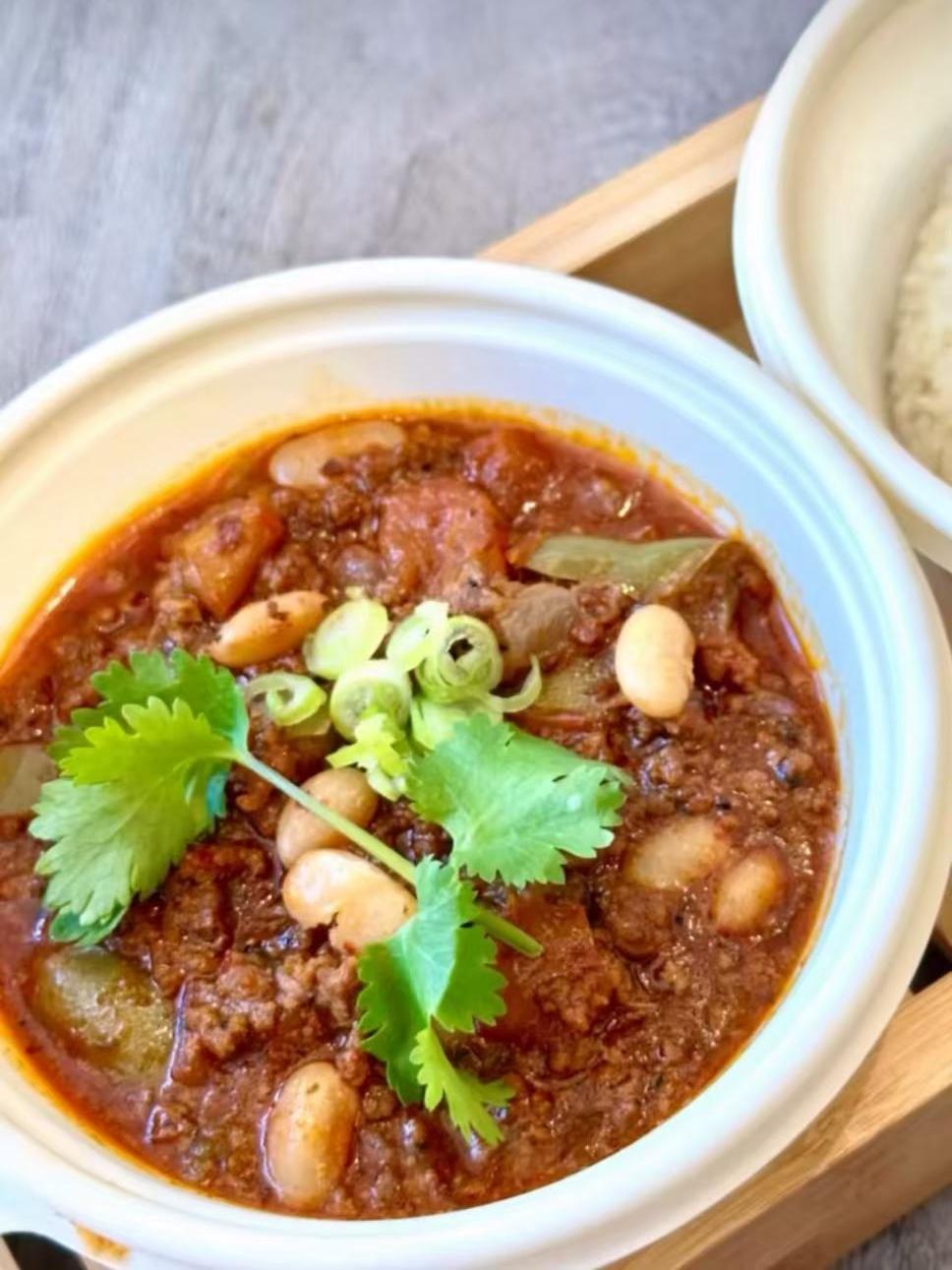 Chili con carne with beans and cilantro garnish at EatGrand, a Japanese Restaurant in Los Angeles