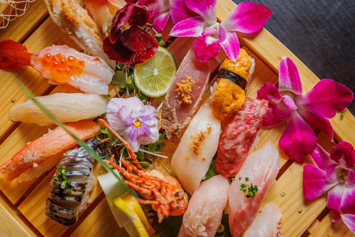 A wood-grain-patterned plate holds a variety of sushi combinations.