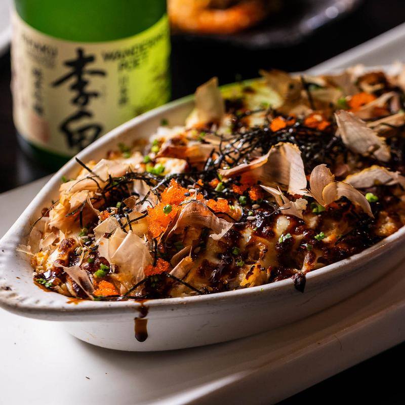 A close-up shot of takoyaki on a white plate.
