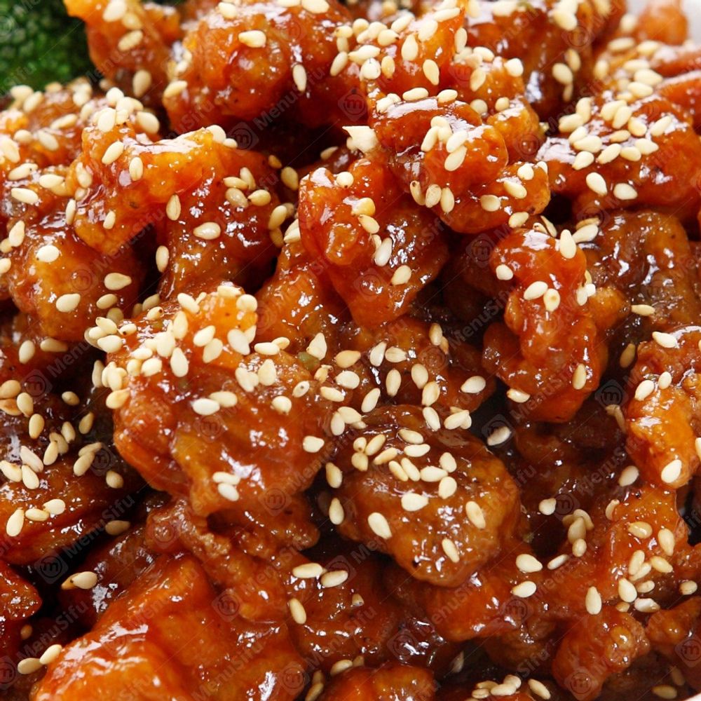 Glazed fried chicken pieces topped with sesame seeds