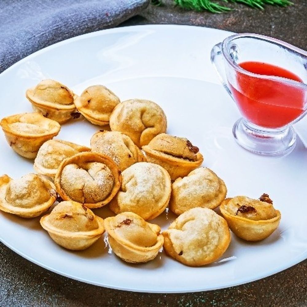 Mini golden pastry cups on a plate with red dipping sauce