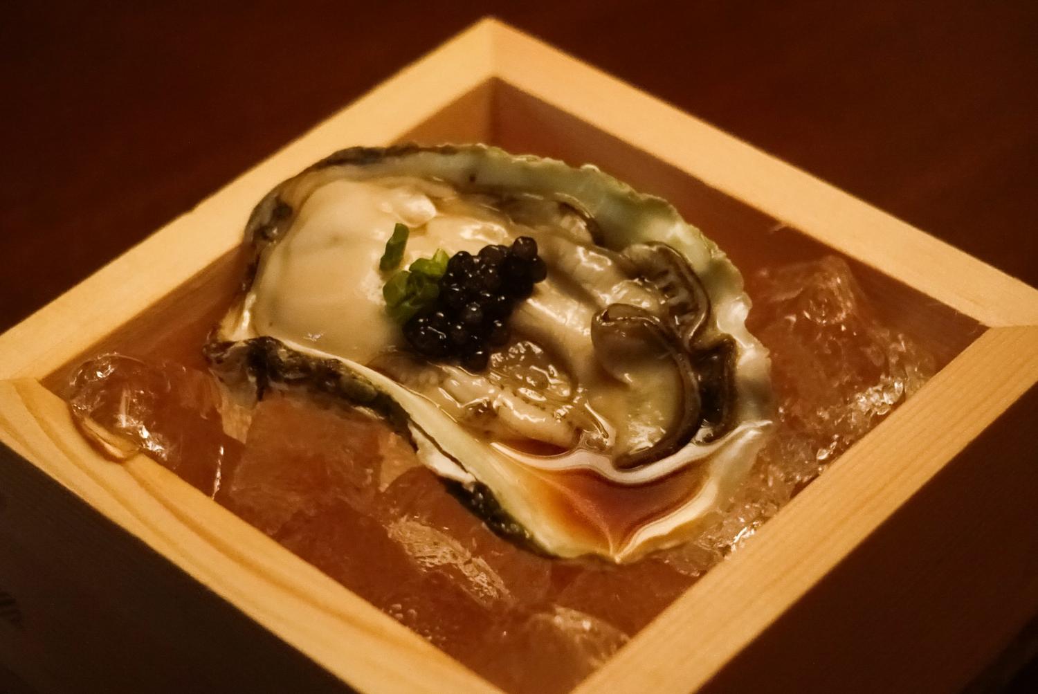 Chilled oyster topped with caviar on ice wooden box at EGAWA, a Japanese Restaurant in Malvern