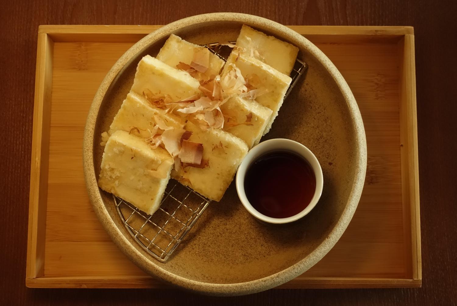 Pan-fried rice cake topped with bonito flakes & sauce at EGAWA, a Japanese Restaurant in Malvern