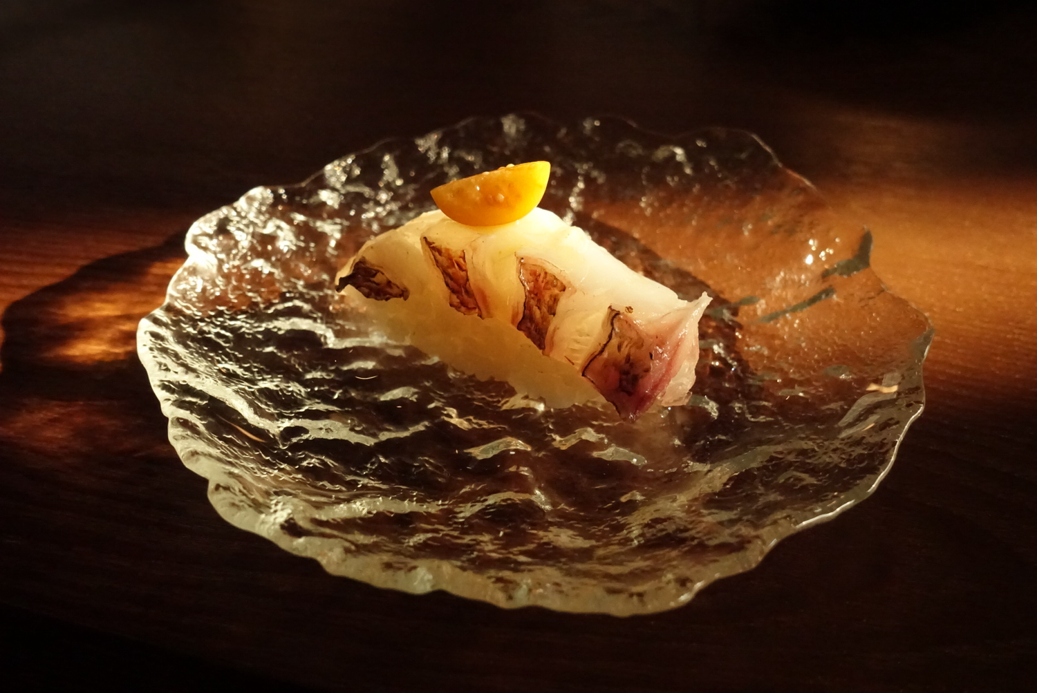 Sea bream nigiri sushi on textured glass plate at EGAWA, a Japanese Restaurant in Malvern