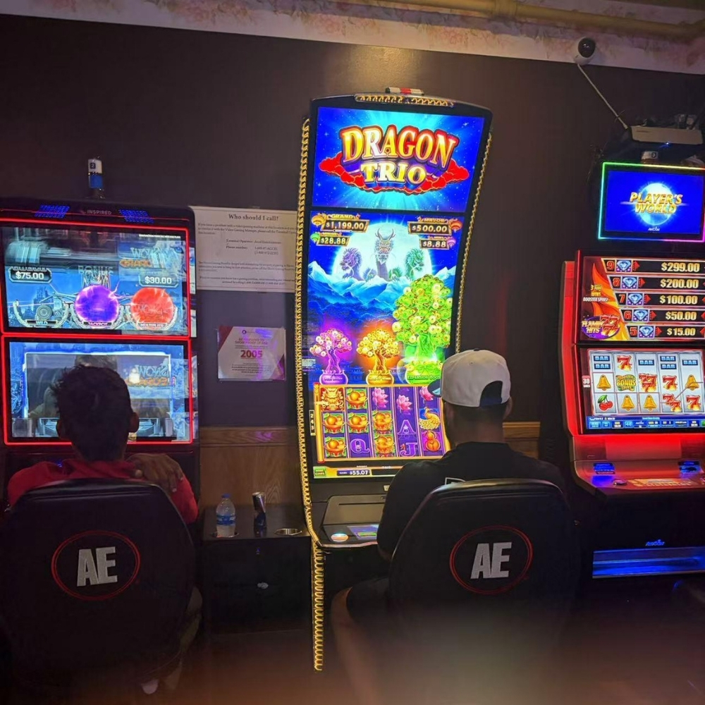 Back view of two men sitting and operating slot machines at Elgin Buffet, a Buffet Restaurant in Elgin