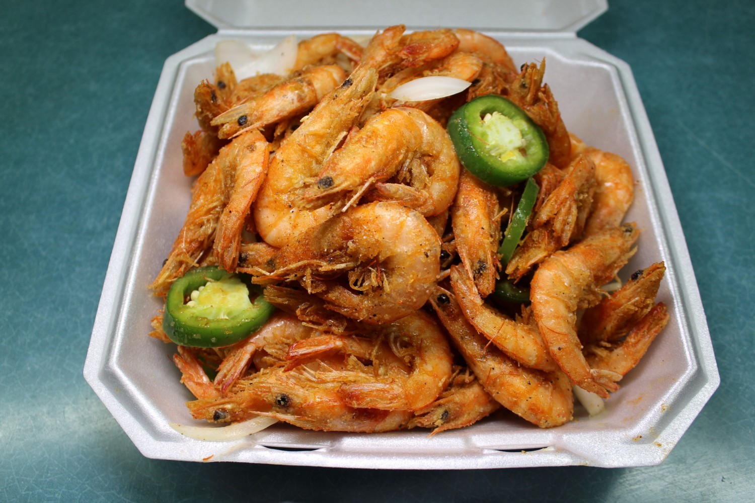 Crispy seasoned fried shrimp with onion and jalapeño in foam box at Elgin Buffet, a Buffet Restaurant in Elgin