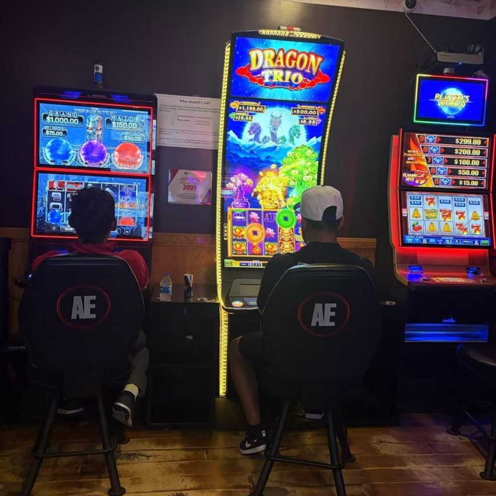 Two guests playing slot machines including Dragon Trio at Elgin Buffet, a Buffet Restaurant in Elgin