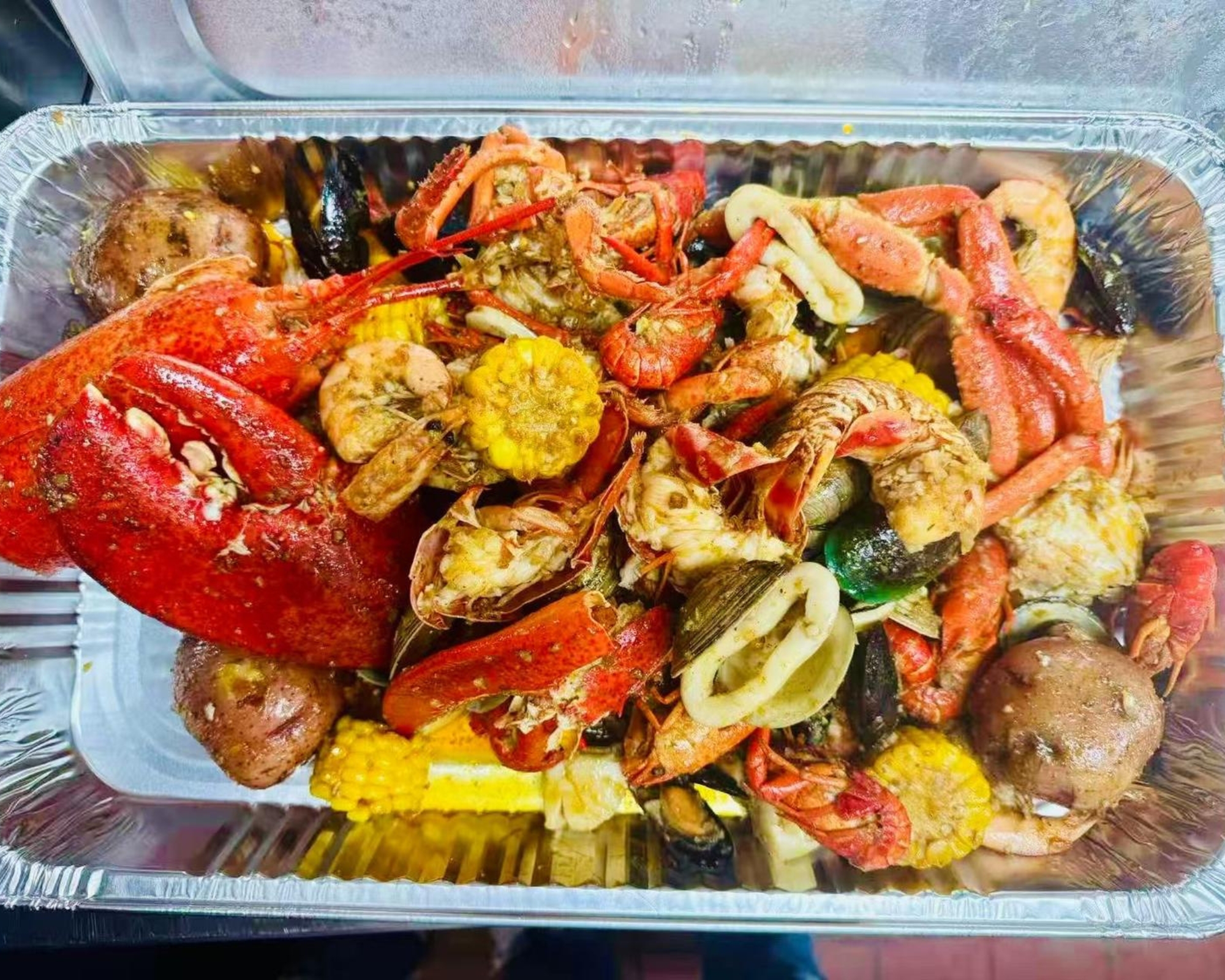 Empire-Wings-Chicken-Wings-Restaurant-Seafood-Combo-Brooklyn Assorted seafood boil with corn and potatoes at Empire Wings, a Chicken Wings Restaurant in Brooklyn