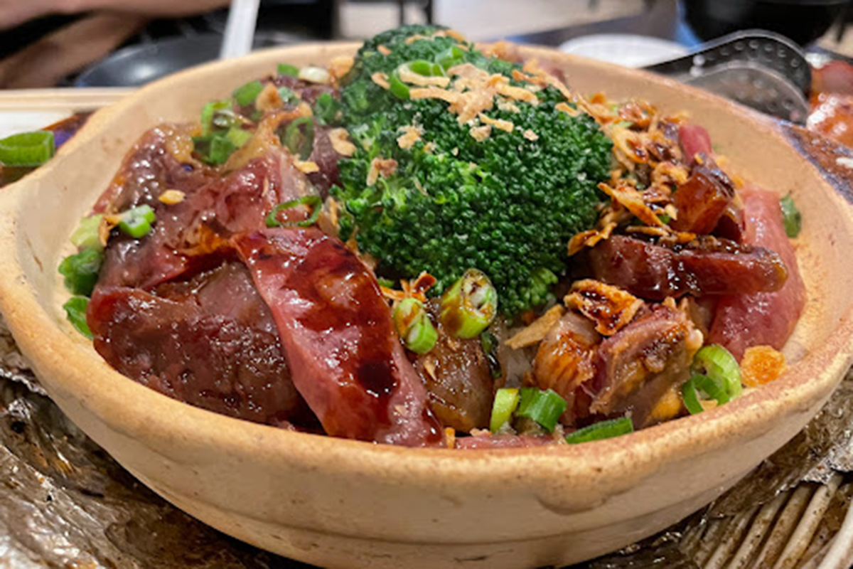 Clay pot rice loaded with cured sausage, beef and broccoli garnished with fried shallots at E Noodle Chinatown, a Chinese Restaurant in New York