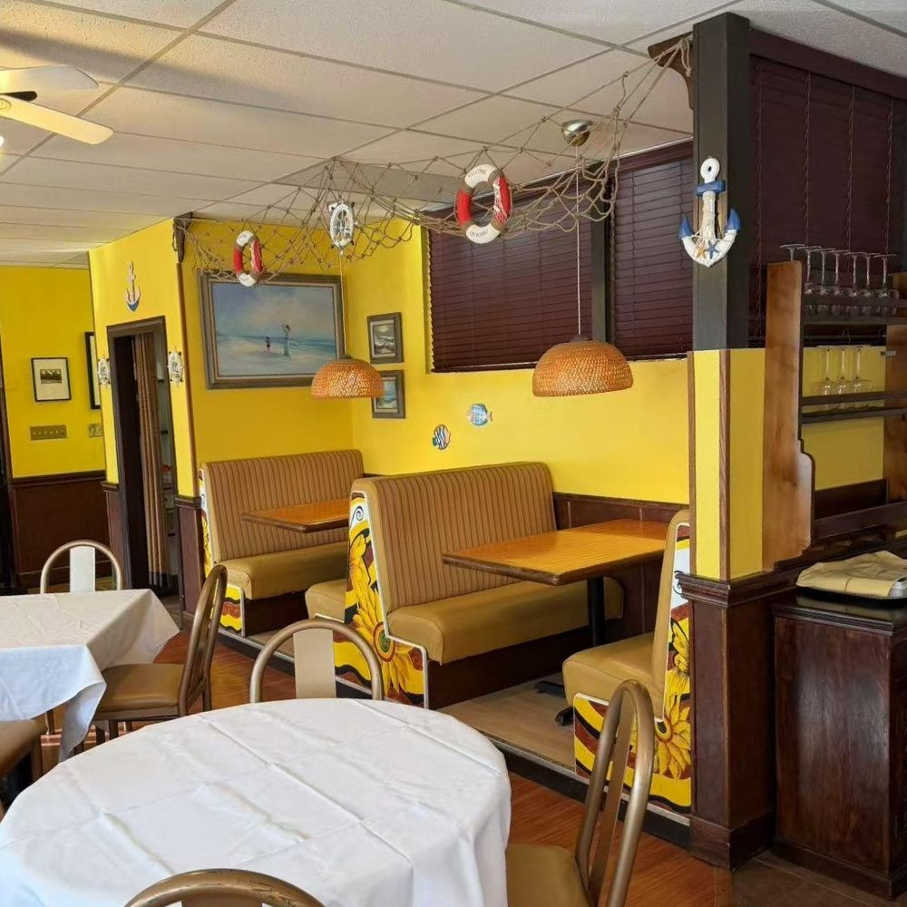 Yellow-walled dining space with booths, art and nautical decor at Raku Sushi, a Japanese Restaurant in Easton