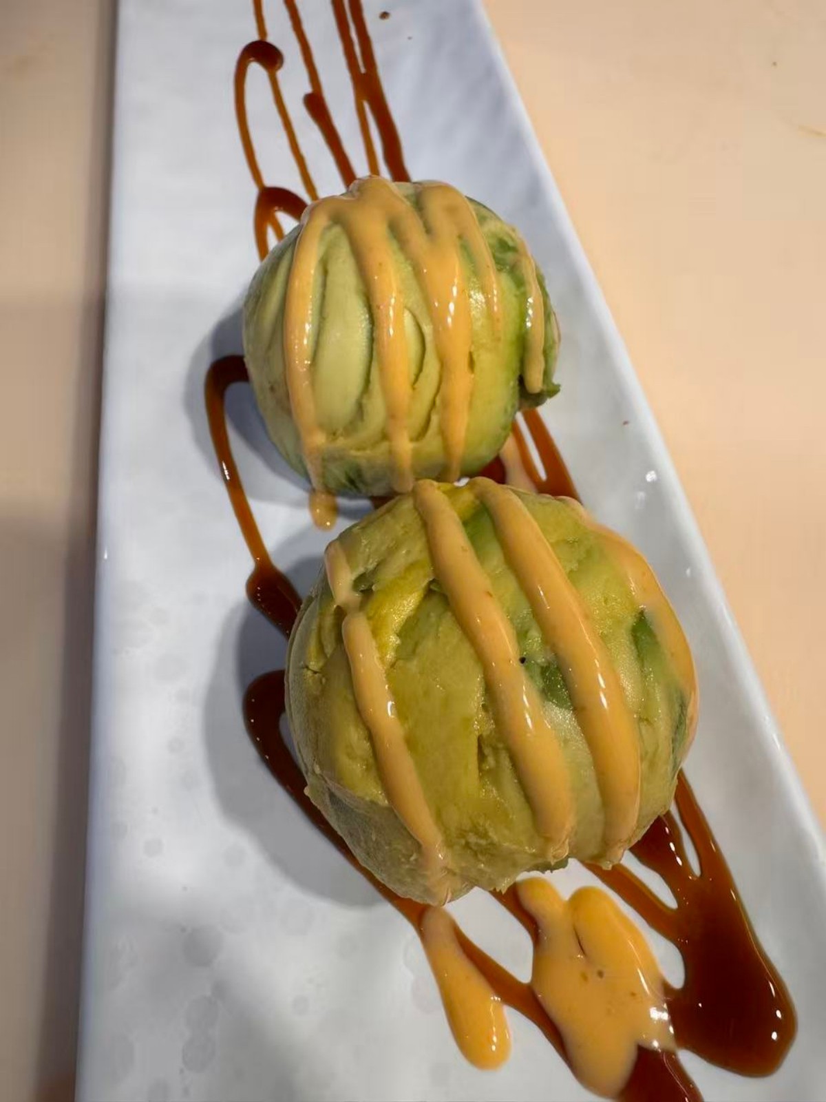 Seasoned avocado balls with spicy mayo, eel sauce at Takumi, a Japanese Restaurant in Fairview Heights