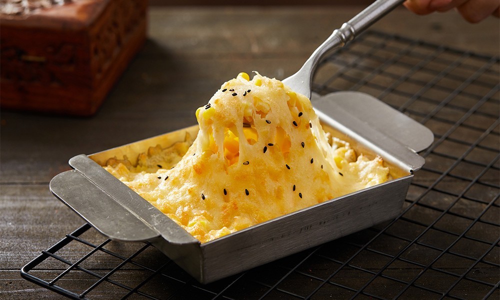 Pulling cheesy baked corn with sesame seeds at FENGMU, a Korean BBQ Restaurant in Rowland Heights