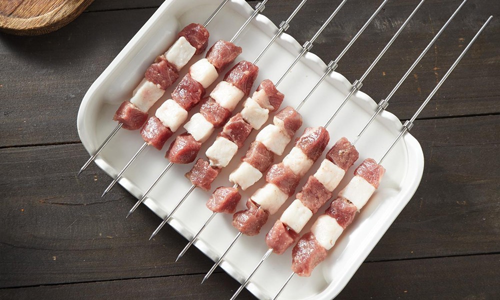 Raw lamb skewers with alternating fat and lean at FENGMU, a Korean BBQ Restaurant in Rowland Heights