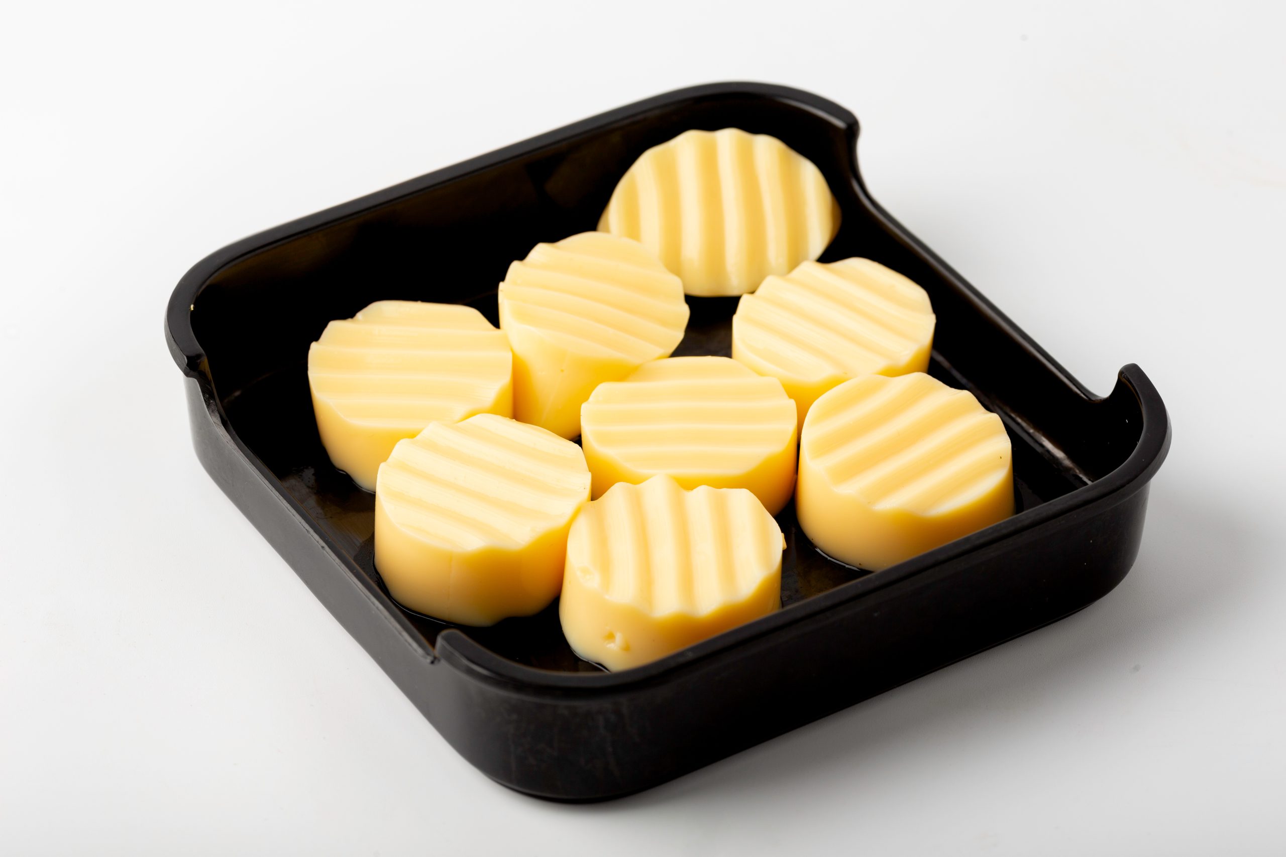 Slices of yellow egg tofu in a black tray at Firestone Hotpot & BBQ Restaurant in Tallahassee