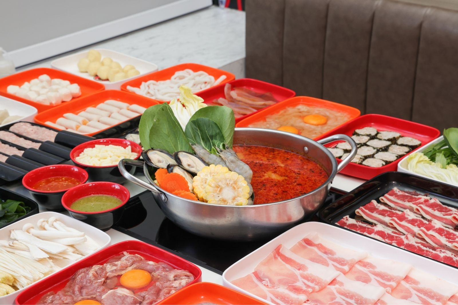 A boiling hot pot surrounded by fresh ingredients at Firestone Hotpot & BBQ Restaurant in Tallahassee