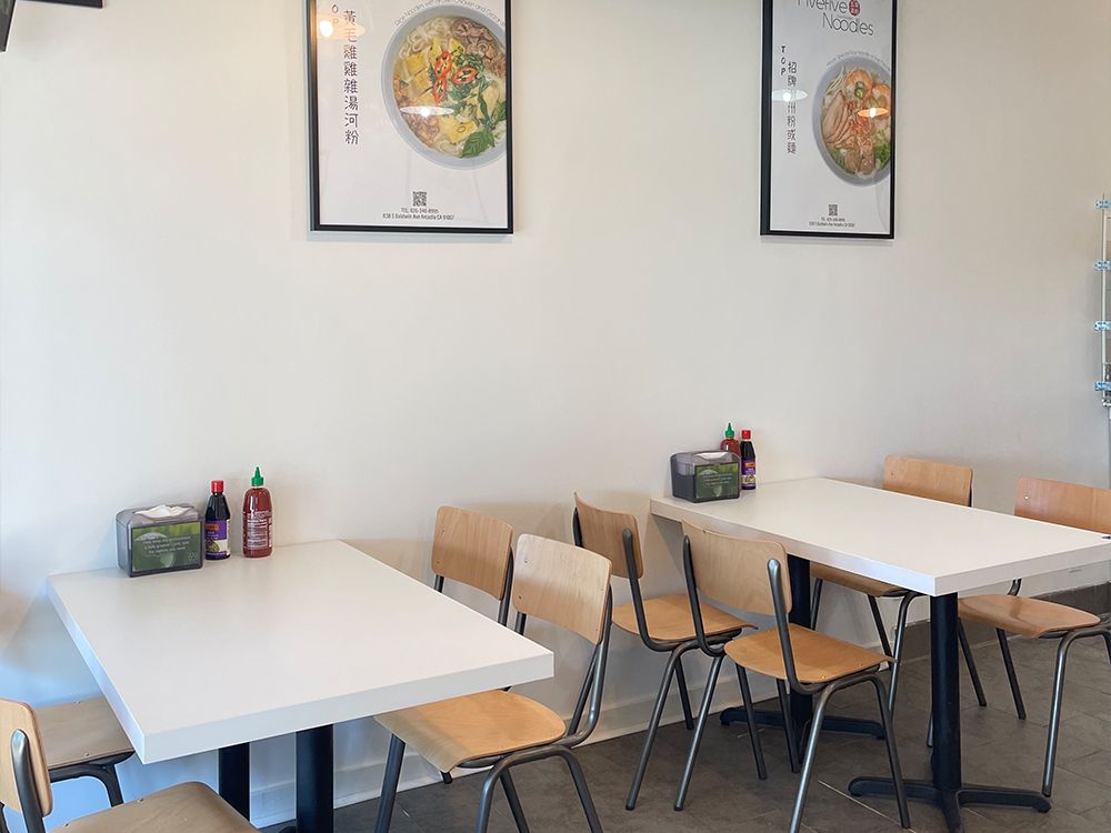 Fivefive Noodles restaurant dining area with tables, chairs, and menu posters