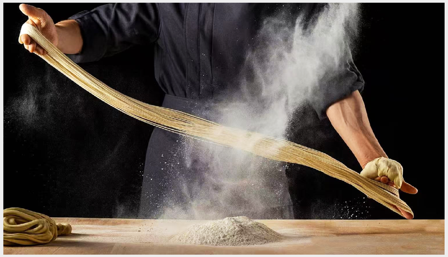 Chef pulls dough into strands with flour at First Meeting Noodle, a Chinese Restaurant in Rochester