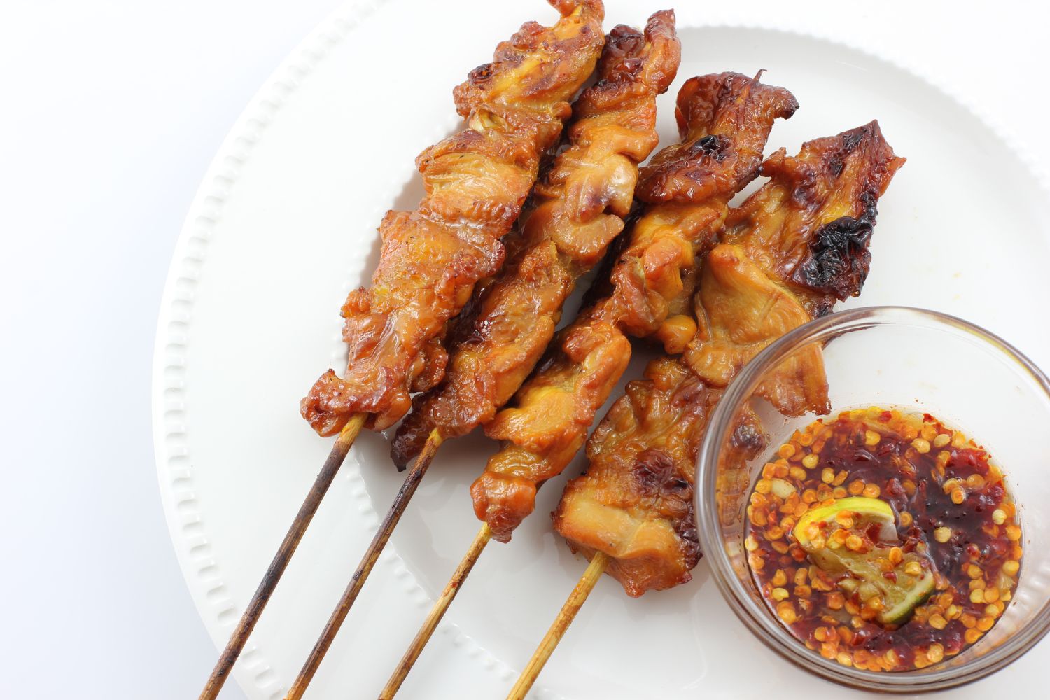 Glazed grilled chicken skewers served with spicy dipping sauce at Foodie BBQ & Bar, a Chinese Restaurant in New York
