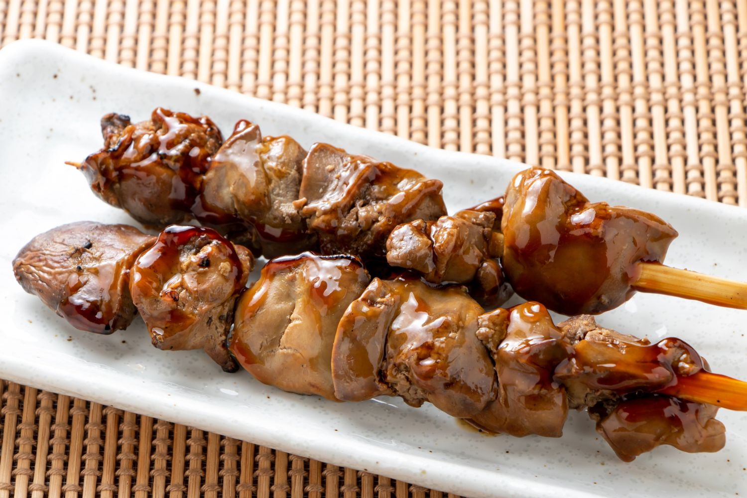 Savory grilled chicken liver skewers coated in dark sauce at Foodie BBQ & Bar, a Chinese Restaurant in New York