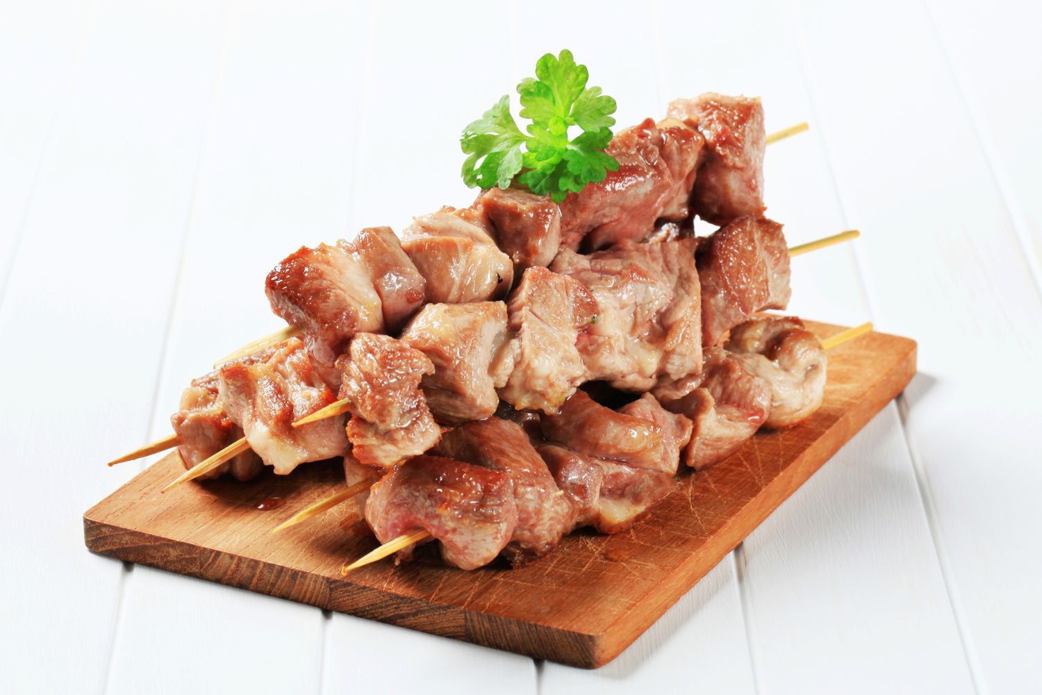 Juicy grilled pork cubes skewers garnished with parsley at Foodie BBQ & Bar, a Chinese Restaurant in New York