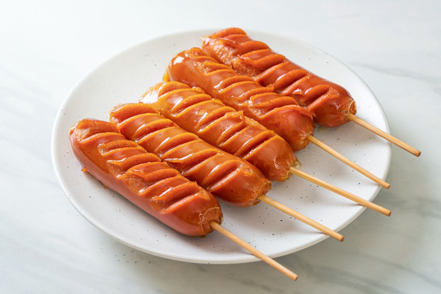 Slit grilled sausages on skewers with glossy glaze at Foodie BBQ & Bar, a Chinese Restaurant in New York