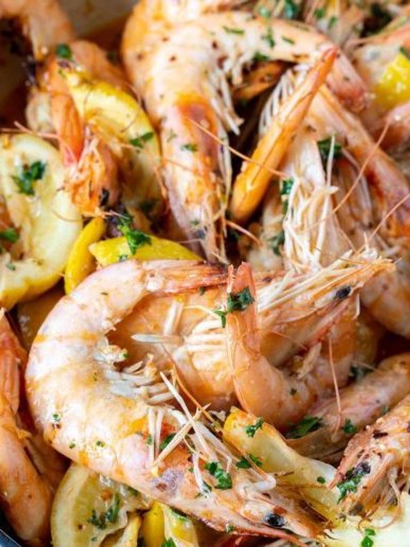 Seasoned boiled shrimp garnished with lemon slices and chopped parsley