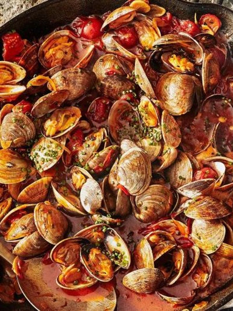 Spicy steamed clams cooked with tomatoes, chili and chopped green herbs