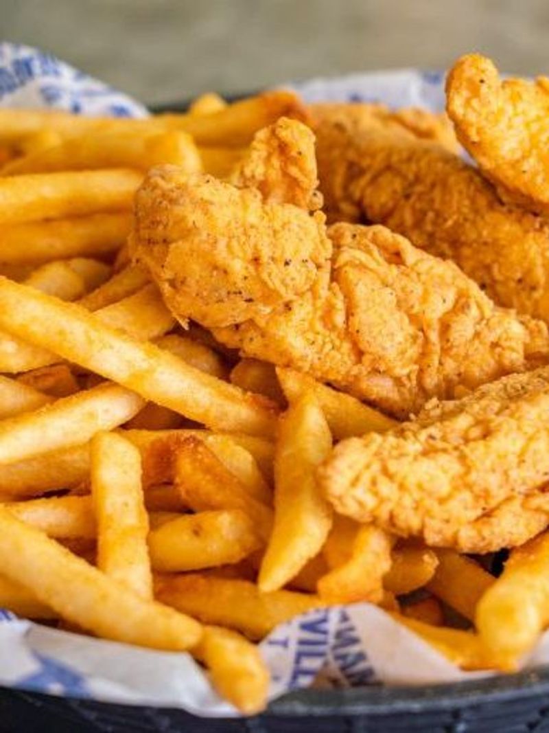 Crispy fried chicken tenders served with golden french fries in a basket