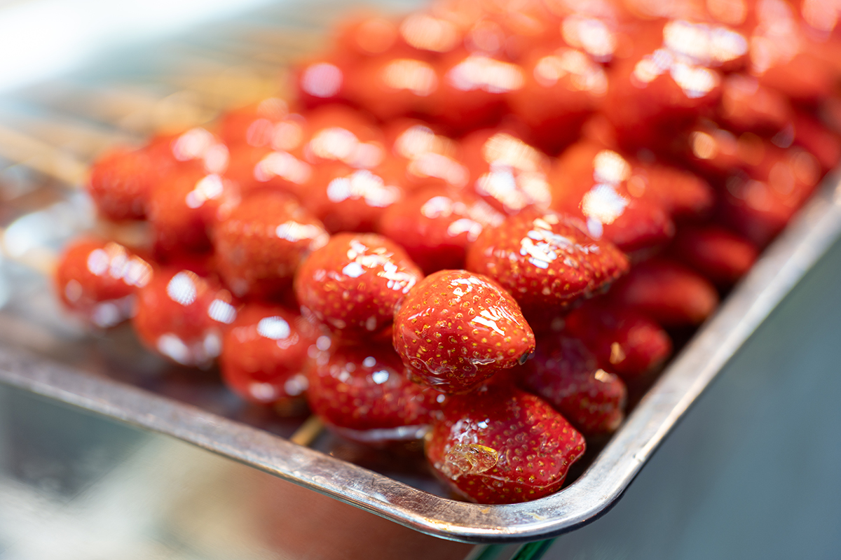 Candied strawberries on skewers with shiny sugar coating at Fruitbite Smoothie, a Smoothie & Fruit Tea Shop in Broomfield