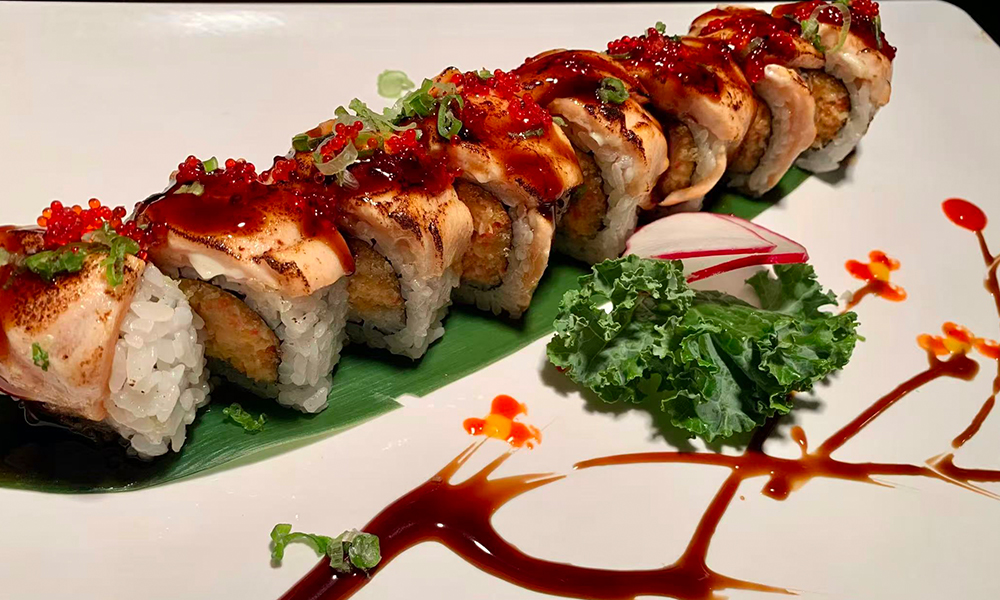 Grilled salmon sushi roll with sauce, tobiko, and green onions. Aburi Salmon Sushi Roll at Fuji Hibachi&Sushi in Monroe