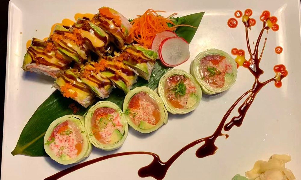 Innovative sushi rolls with avocado, crab, and artistic sauce design. Aburi Salmon Sushi Roll at Fuji Hibachi&Sushi in Monroe