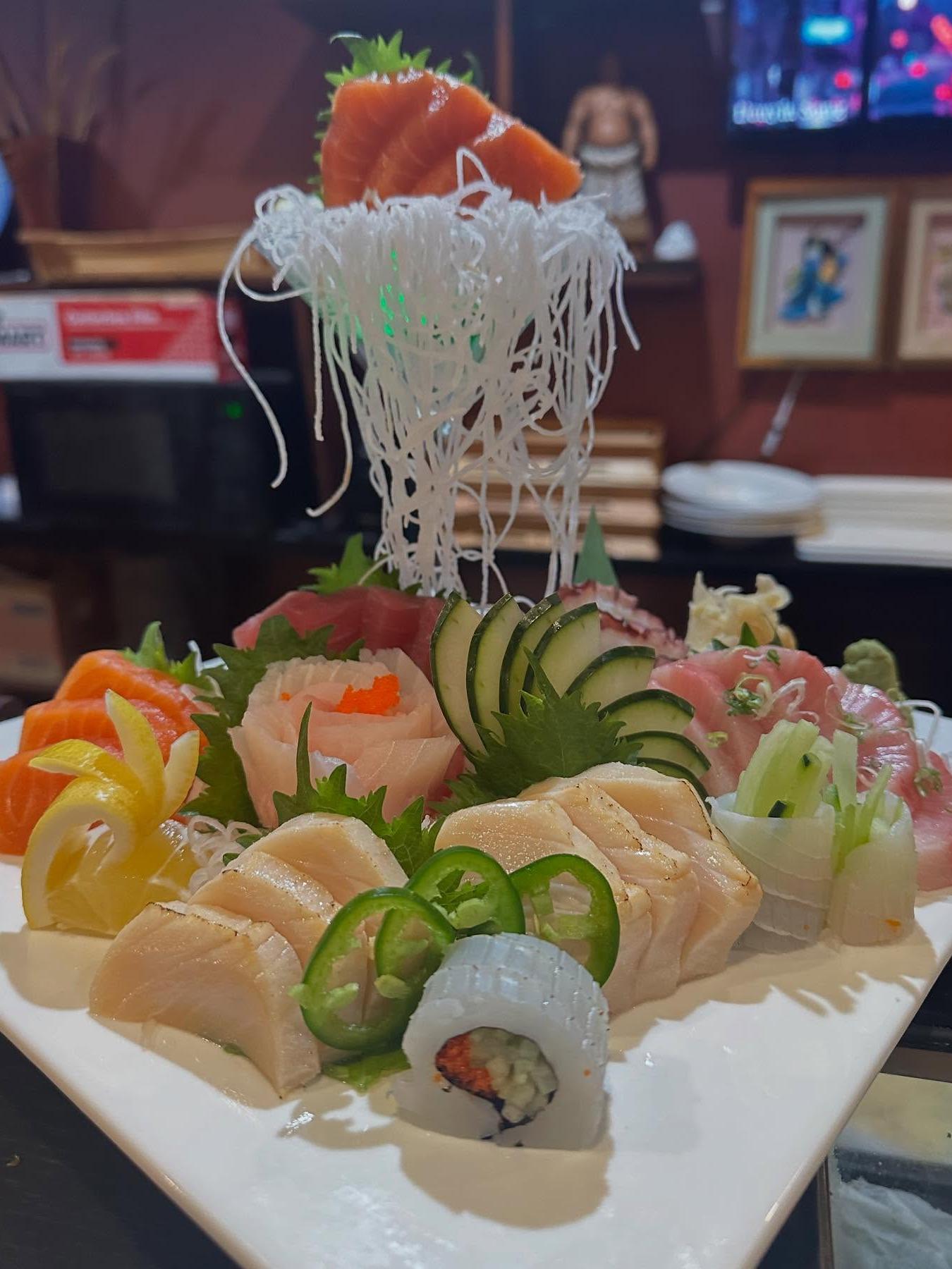 Hibachi and Sashimi – Hibachi cooking show and sashimi platter with fresh fish at Fuji Hibachi & Sushi Steakhouse, a Japanese restaurant in Edgewater Sashimi Platter - Assorted fresh sashimi slices, garnished with cucumber and radish at Fuji Hibachi & Sushi Steakhouse, a Japanese restaurant in Edgewater
