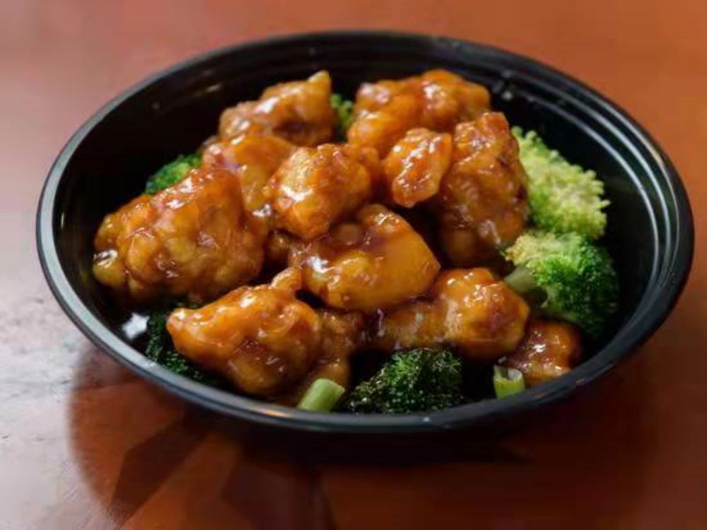 Crispy chicken chunks coated with orange sauce with broccoli
