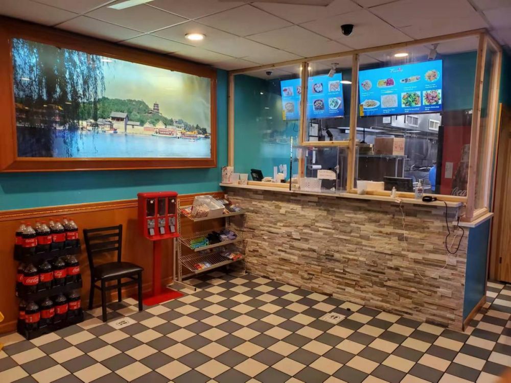 Interior counter of a Chinese takeout restaurant with menu screens