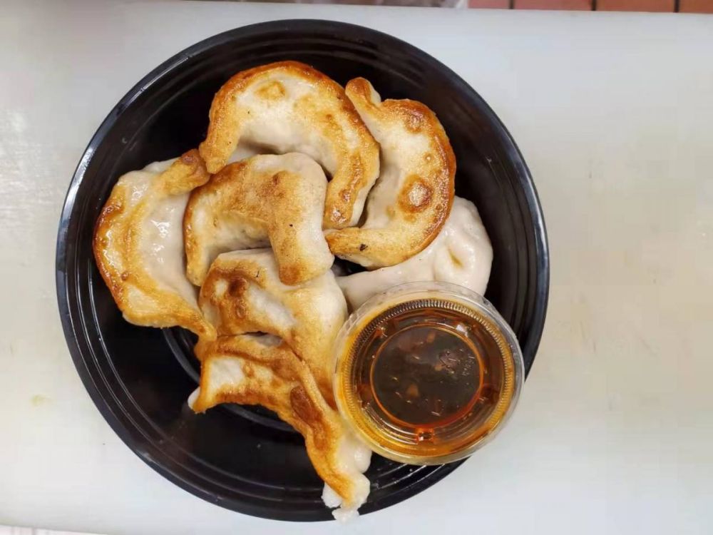 Pan-fried dumplings served with spicy dipping sauce