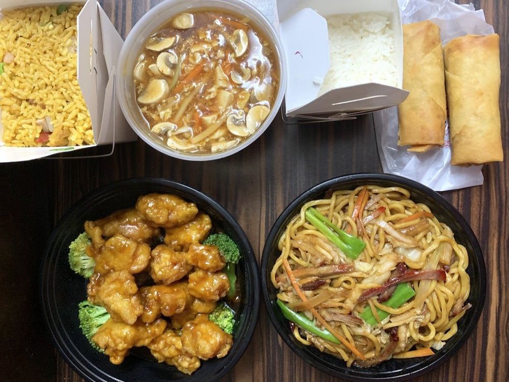 Variety of classic Chinese takeout dishes on wooden table